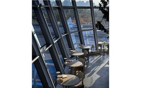 Photo Of inside an office or a restaurant near the road. Some tables are placed by the window wall.