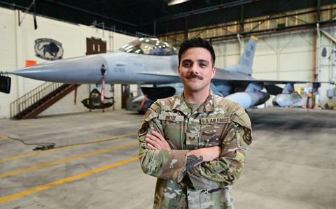 Photo Of U.S. Air Force Staff Sgt. Erik Ortiz, 8th Maintenance Group lead crew chief, poses for a photo in front of an F-16 Fighting Falcon aircraft.