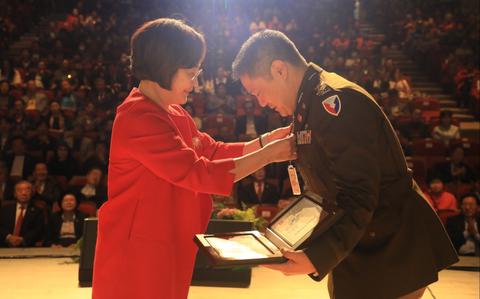 Photo Of U.S. Army Col. Edward Cho receives an honorary citizenship award on the stage. There are many audience.