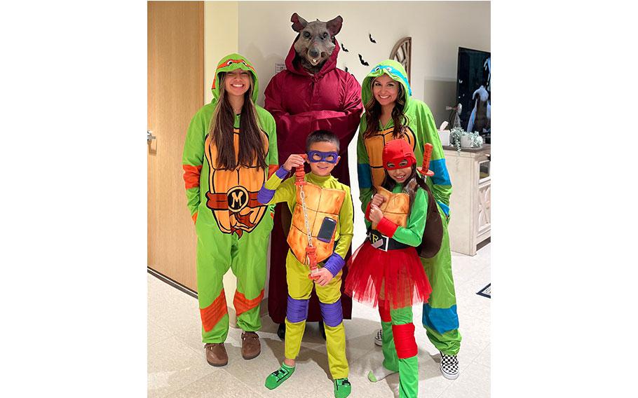 4 people wears costume of the ninja turtles, and 1 person wears an animal mask.