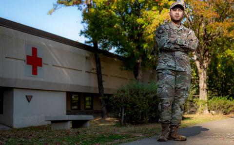 Photo Of U.S. Air Force Senior Airman Jomar Cabigting poses with his arms folded in front of a building.