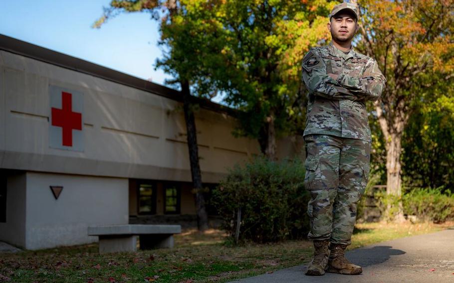 U.S. Air Force Senior Airman Jomar Cabigting poses with his arms folded in front of a building.