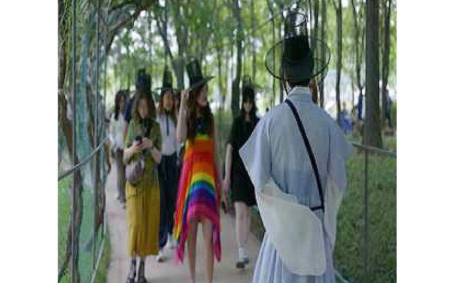 Foreigners walk in a Korean garden.