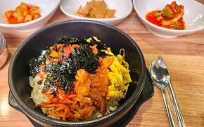 Bibimbap and some kimchi on the table.