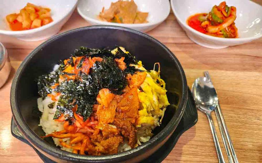 Bibimbap and some kimchi on the table.