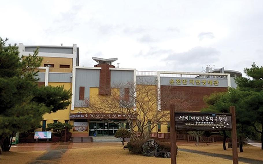 Photo of Natural Ecology Center building. Some trees are near the front doors.