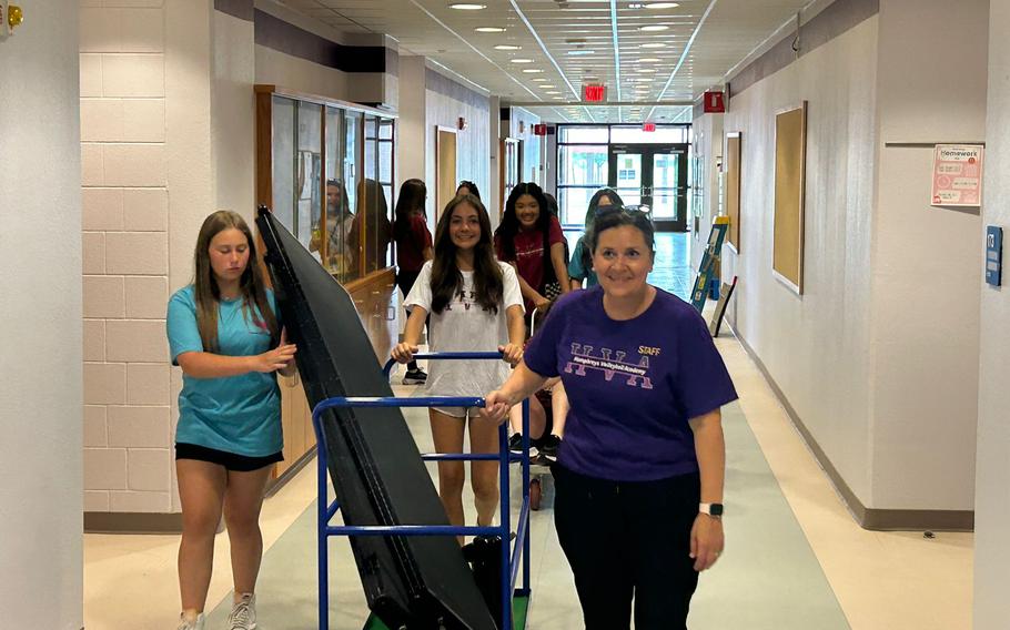 Volunteers moves equipment from classrooms.
