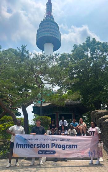 Participants pose for a photo in front of the tower.
