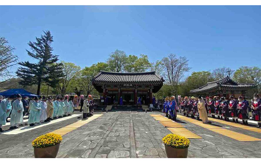 Some people are facing each other in front of Deokyangjeon.