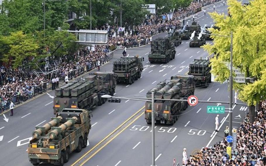 MIlitary parade in South Korea. Some military vehicles are parading on the road.