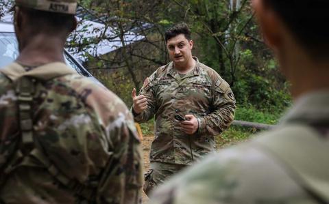 Photo Of U.S. Army Sgt. Christopher Strunck gives instructions for land navigation to students by a car at Camp Casey, Oct. 15, 2024.