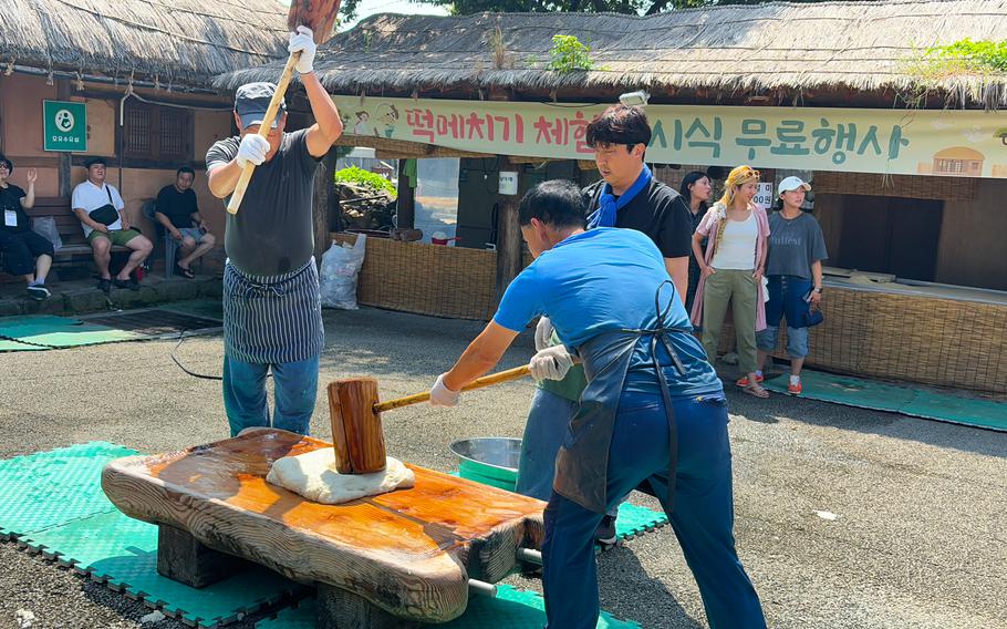 Three people are making rice cake.