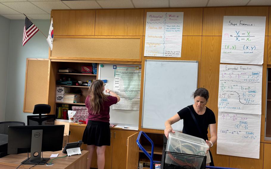 Two volunteers setting up classroom.