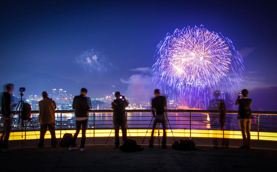 several people are taking photos of fireworks.