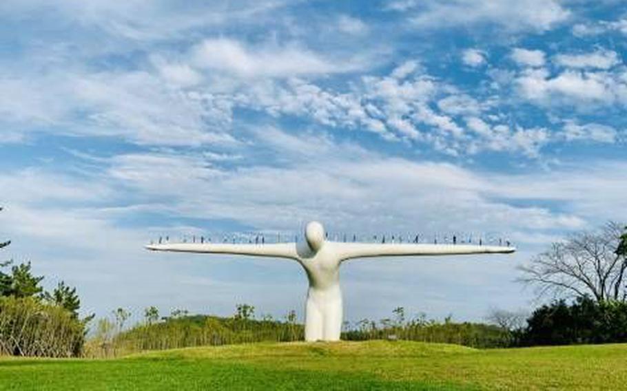 Bridge of Human sculpture on the lawn.