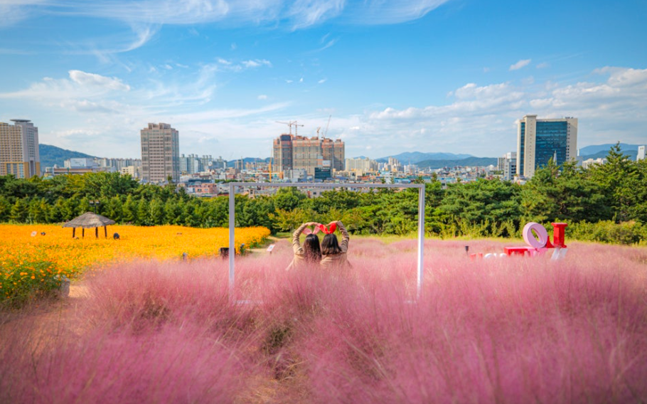 two ladies are taking a photo in front of plants at Eworld.