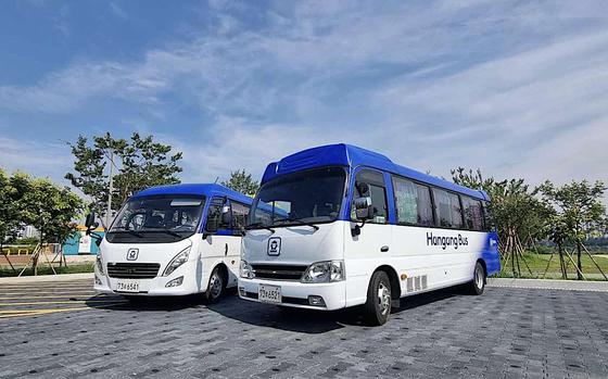 Two buses are parked in the parking lot.
