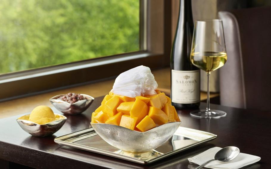 Mango bingsu and a glass of champagne are on the table.