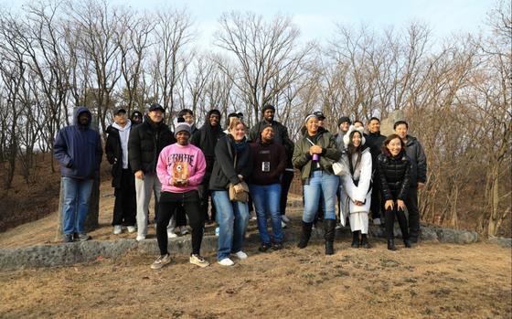 A group of 21 U.S. Soldiers, KATUSAs, and civilians assigned to U.S. Army Garrison Yongsan-Casey and 210th Field Artillery Brigade take a commemorative photo at General Eo, Yu-so’s tomb on Camp Hovey.