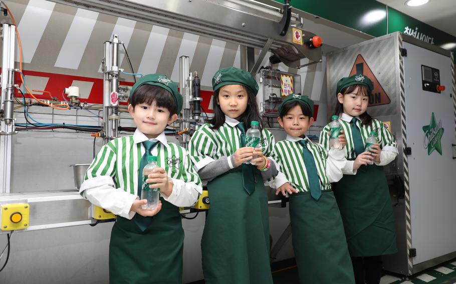 Kids with a bottle on their hands pose for a photo.