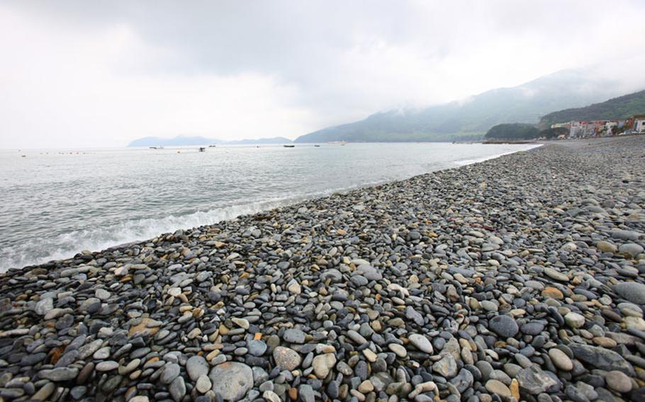Hakdong Black Pearl Pebble Beach. Some ships can be seen.