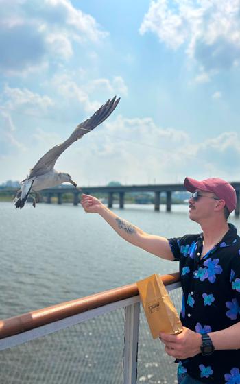 One of the participants is feeding a bird on a cruise.