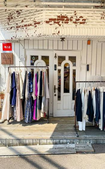 The exterior of one of the antique shops in Itaewon Antiques Street. Pieces of clothing are displayed by the door.