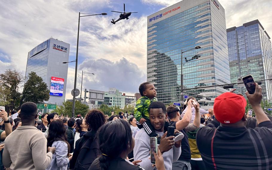 many visitors are taking photos of military parade.