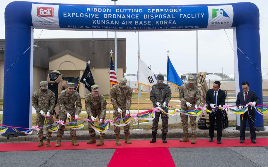 8 people are cutting ribbons at the ceremony.