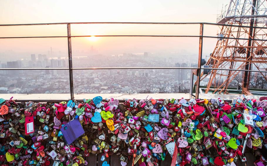 many locks are attached to the tower’s fence..