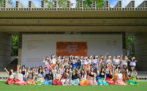 Photo Of About 50 participants pose in front of the stage.