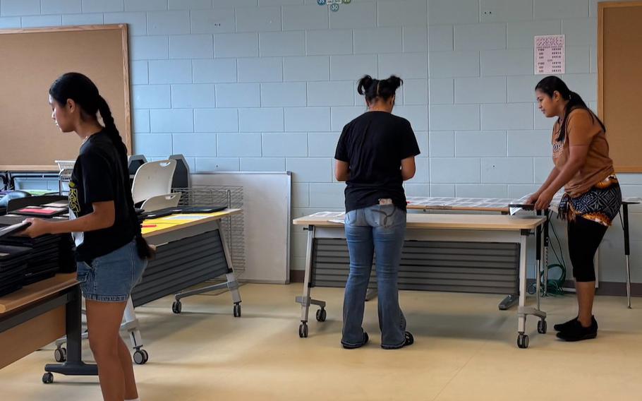 Military spouse and daughters assisting with classroom moves and preparing labels.