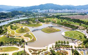 An aerial photograph of Suncheon Lake Garden. A pond is in the center of the photo. 