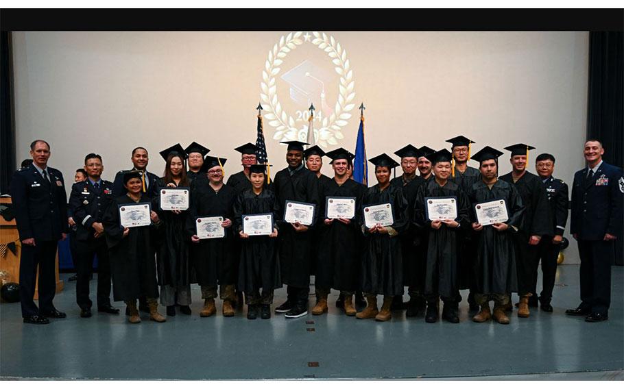 Master’s degree recipients pose with base leadership during the Joint Force Graduation ceremony at Kunsan Air Base.