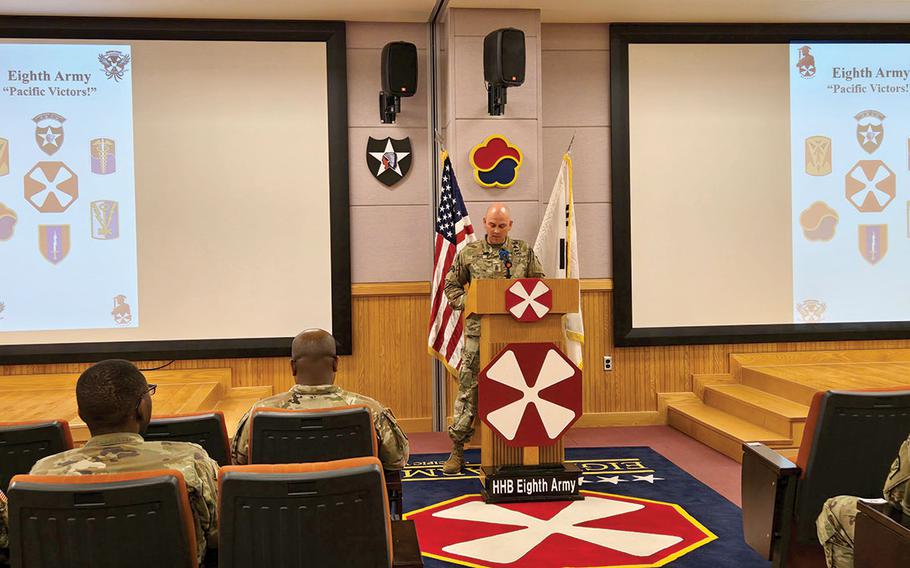 A military personnle is giving a speech during a patch ceremony.