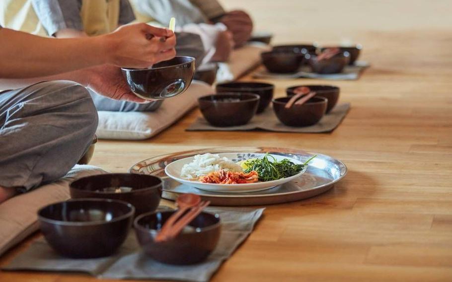 Templestay participants dining with balwoo, traditional Buddhist tableware. 
