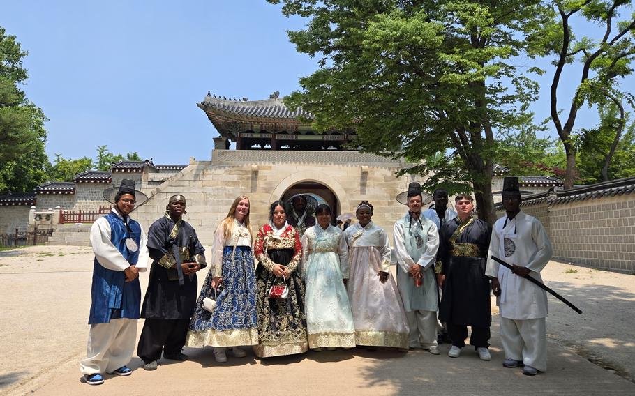 Participants pose for a photo in front of a gate.