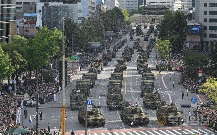 MIlitary parade in South Korea. Some military vehicles are parading on the road.