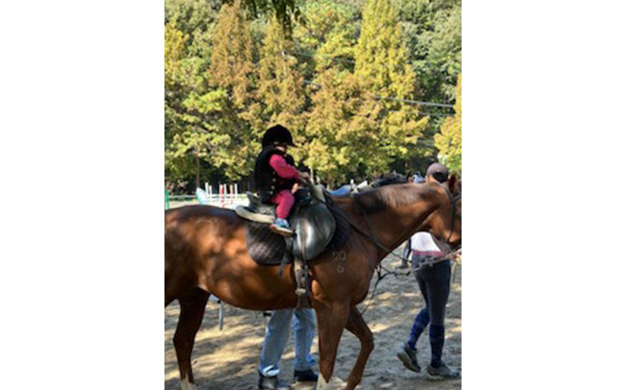 a kid enjyoing horse-riding.