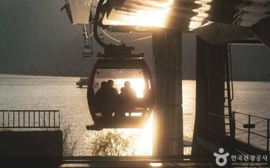 Several people in a cable car enjoy the scenery.