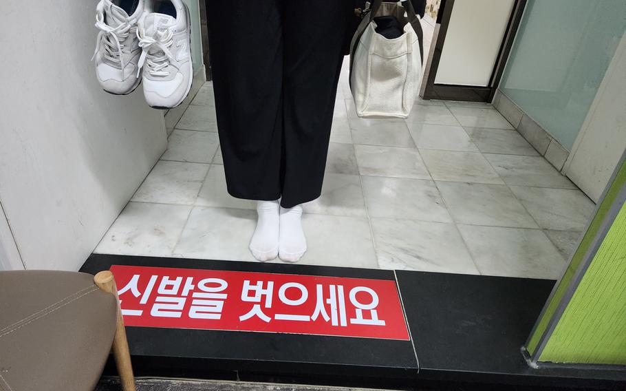 a person removes their shoes at the counter.