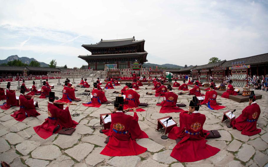 People are playing instruments with traditional costumes.