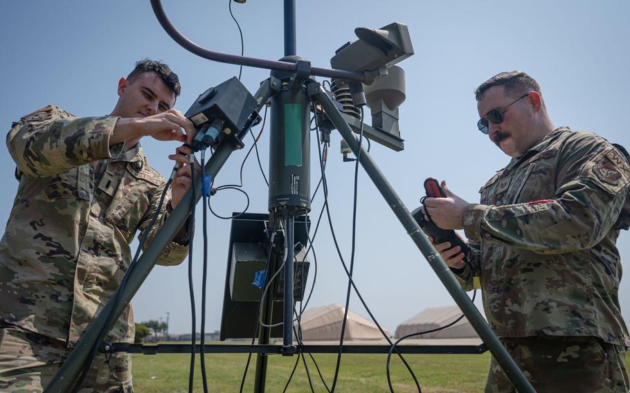 1st Lt. Evan Cade, 8th Operations Support Squadron weather flight commander, left, and Tech. Sgt. Austin Young, 8th OSS non-commissioned officer in charge of airfield weather operations, examine weather monitoring equipment at Kunsan Air Base, Republic of Korea, May 21, 2024. The 8th OSS Weather Flight has the proper tools and equipment to gather meteorological data throughout the monsoon season, enabling them to alert the base about significant weather conditions in advance.