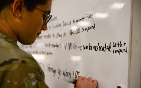 Photo Of U.S. Air Force 1st Lt. Xiomara Roberge writing on a whiteboard.