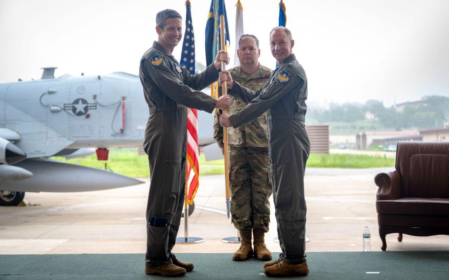 U.S. Air Force Col. Kurt Distelzweig, incoming 51st Operations Group commander, receives the unit guidon from Col. William McKibban, 51st Fighter Wing commander, during a change of command ceremony at Osan Air Base, Republic of Korea, May 22, 2025. The passing of the guidon signifies the official transfer of command to Distelzweig. 