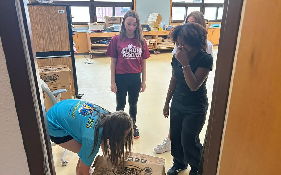 One of the volunteers is trying to lift a box.
