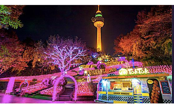 Photo Of illuminated E-World. food booth and tower can be seen.