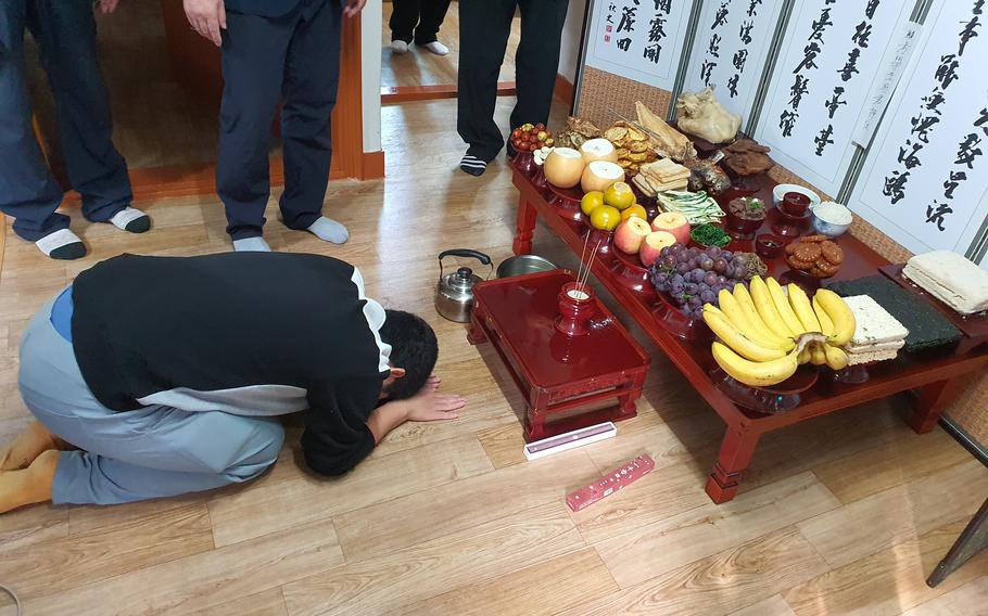 My brother bows twice toward the ritual table during the ancestral rites on Seollal.