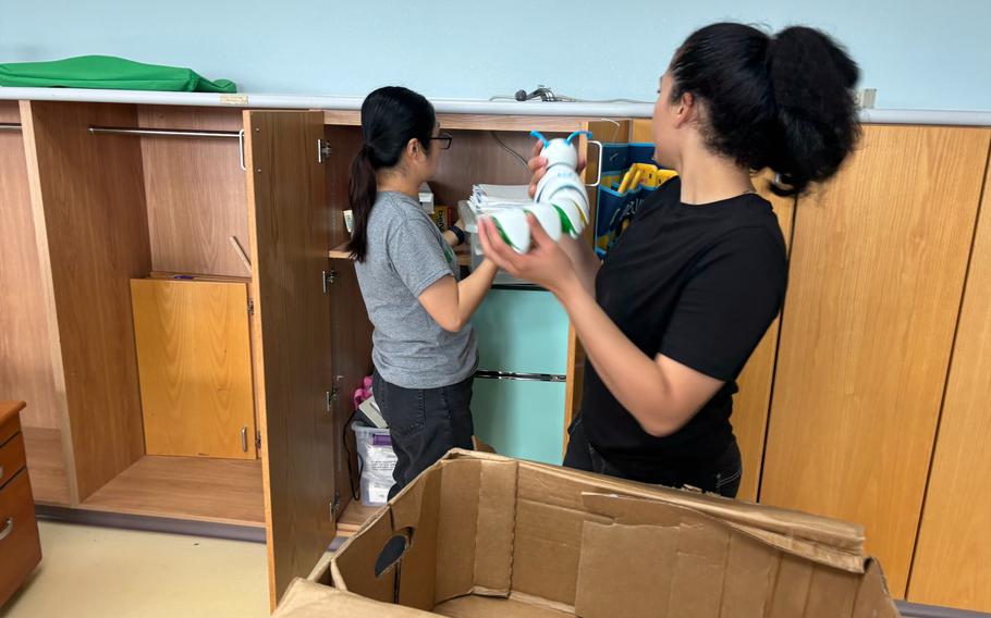 SPC Hang Nguyen (U.S. Army, Delta Co. 125th FI BN) and SPC Martha Angely Vargas (U.S. Army, Delta Co. 125th FI BN) packing items for classroom move.