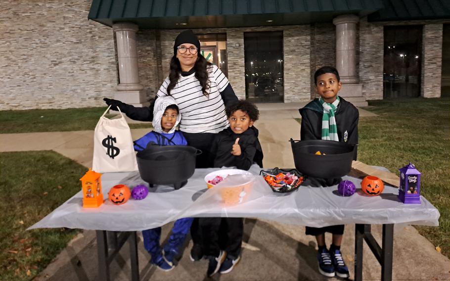 Iris Jones and her boys dressing up behind the table with Halloween goods.